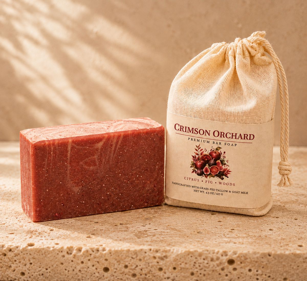 Crimson Orchard grass-fed tallow and goat milk bar soap beside its muslin packaging on a warm neutral background