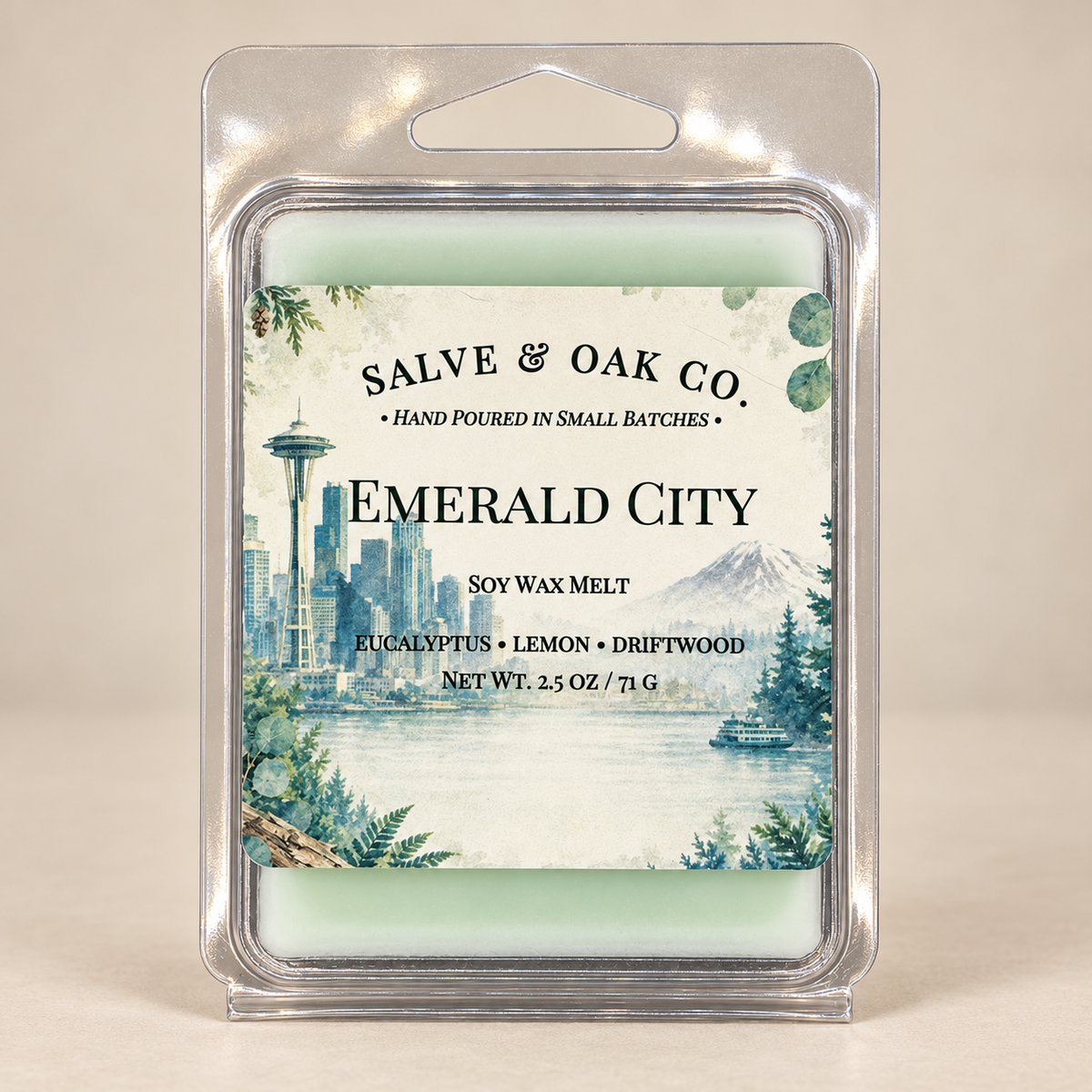 Salve & Oak Co. Emerald City soy wax melt clamshell with pale green wax and a Seattle skyline label against a cream background.

